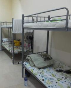 two bunk beds in a small room with a bed at Stay at gomeetingwith in Sharjah