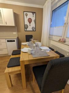 a dining room with a wooden table with chairs at Bis zu 6 Personen, Bahnhofs- & Zentrumsnah, Südheide, Netflix und PS4 in Celle