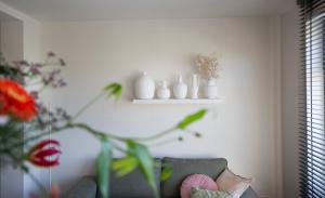 een woonkamer met een bank en een plank met vazen bij Vakantiewoningen Liefst in Epen in Epen