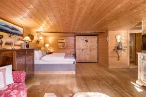 1 dormitorio con cama y techo de madera en "CHALET dei FIORI" room & apartment, en Bedretto