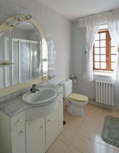 Baño blanco con lavabo y aseo en Casa de piedra en Vilanova de Arousa, en Villanueva de Arosa