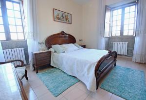 1 dormitorio con 1 cama grande y 2 alfombras en Casa de piedra en Vilanova de Arousa, en Villanueva de Arosa