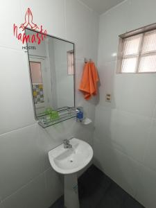 a white bathroom with a sink and a mirror at Namaste Hostel in Tarija +27 photos