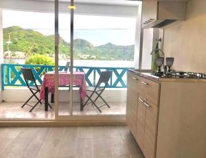 a kitchen with a table and a balcony with a view at Miss Francia´s Home in Santa Catalina Island