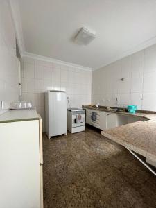 an empty kitchen with a refrigerator and a stove at Grande Família Hostel Av paulista in Sao Paulo