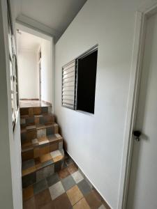 a hallway with a staircase with a window at Grande Família Hostel Av paulista in Sao Paulo