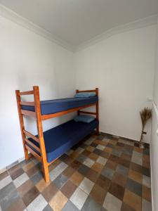 a bunk bed in a room with a checkered floor at Grande Família Hostel Av paulista in São Paulo