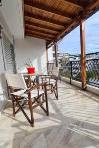 a patio with a table and chairs on a balcony at Fori's Nest / SKG in Thessaloniki