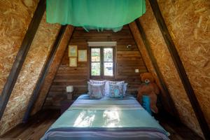 - une chambre avec un lit dans une cabane en rondins dans l'établissement Vale da Silva Villas - Quinta, à Albergaria-a-Velha
