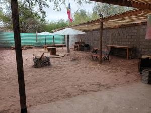 un patio avec des tables et des parasols dans le sable dans l'établissement Hostal Ribera de Quitor, à San Pedro de Atacama