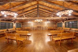 Duży pokój z drewnianymi stołami i ławkami w obiekcie The Meeker Park Lodge w mieście Allenspark