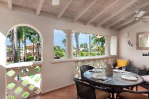 a balcony with a table and chairs and two windows at Paradise Palms Sugar Hill in Saint James