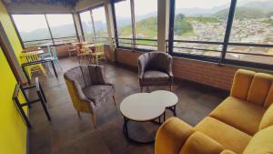 ein Zimmer mit Stühlen, einem Sofa und einem Tisch in der Unterkunft Hotel Entre Brumas in Aguadas