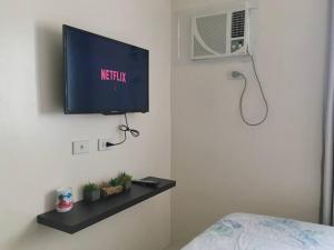 a room with a television on a wall at Condo , WIFI up to 100mbps , Infinity Pool in Cebu City