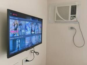 a flat screen tv hanging on a wall at Condo , WIFI up to 100mbps , Infinity Pool in Cebu City +36 photos