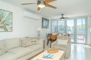 a living room with a couch and a ceiling fan at Modern Beach Walk at Puerto Bahia #30 in Rincon