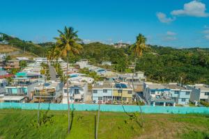 Vista arial a uma cidade com casas e palmeiras em Modern Beach Walk at Puerto Bahia #30 em Rincon