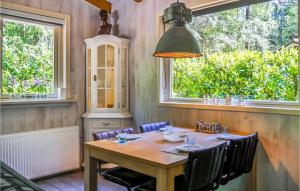 a dining room with a wooden table and two windows at De Koekoek in Emst