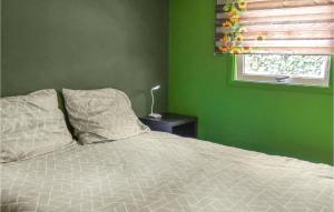 a green bedroom with a bed and a window at De Koekoek in Emst