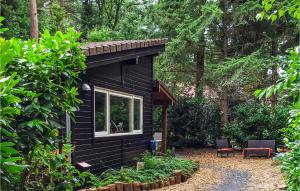 ein schwarzes winziges Haus mitten im Wald in der Unterkunft De Koekoek in Emst