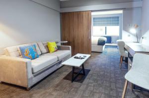 a living room with a couch and a table at Sandman Signature Aberdeen Hotel & Spa in Aberdeen