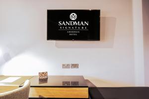 a flat screen tv hanging on a wall at Sandman Signature Aberdeen Hotel & Spa in Aberdeen