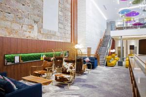 a lobby with couches and chairs and a staircase at Sandman Signature Aberdeen Hotel & Spa in Aberdeen