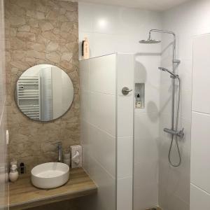 a bathroom with a sink and a shower with a mirror at Casa Rural Y Spa de Regina in Turballos