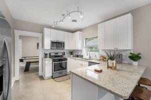 a kitchen with white cabinets and a counter top at Contemporary Cottage near zoo and Rhodes college in Memphis