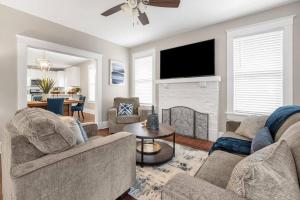 a living room with two couches and a tv at Contemporary Cottage near zoo and Rhodes college in Memphis