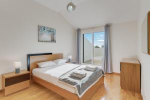 a bedroom with a bed and a large window at Anje Apartamento in Funchal