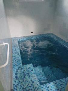 baño con piscina de azulejos azules en KEUR DIAM - Maison de la Paix, en Saly Portudal