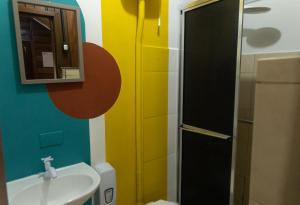 a bathroom with a sink and a toilet and a mirror at Pousada Orquideas in Ilha do Mel