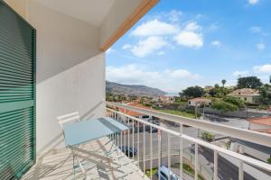 a balcony with a chair and a view of a city at Anje Apartamento in Funchal