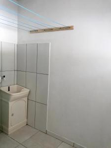 Baño blanco con lavabo y aseo en Residencial Casa da Vila apto 3, en Imbituba