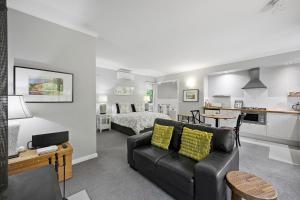 a living room with a couch and a bedroom at Amelina Cottages in Marysville