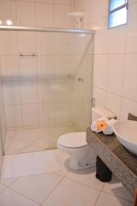 a bathroom with a shower and a toilet and a sink at Pousada Vila Palma Boipeba in Ilha de Boipeba