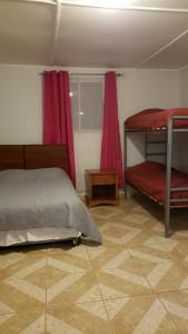 een slaapkamer met 2 stapelbedden en rode gordijnen bij Hostal Ribera de Quitor in San Pedro de Atacama