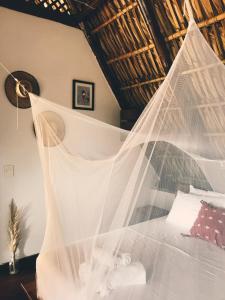 a bedroom with a bed covered in mosquito net at Casa Zala in El Paredón Buena Vista
