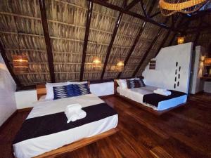 2 Betten in einem Zimmer mit Holzböden in der Unterkunft Casa Zala in El Paredón Buena Vista