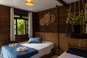 um quarto com 2 camas e toalhas em Pousada Orquideas na Ilha do Mel