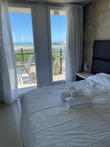 Schlafzimmer mit einem Bett und Strandblick in der Unterkunft Linda Bay Premium Resort in Mar de las Pampas
