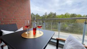 einen Tisch mit zwei Gläsern Wein auf dem Balkon in der Unterkunft Strandhaus Nordseebrandung Fewo A3.1 in Cuxhaven