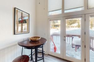 uma pequena mesa e cadeiras num quarto com uma porta de vidro deslizante em Away Out on the Mountain em Crested Butte