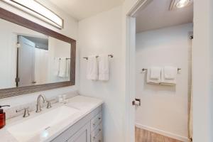 ein weißes Badezimmer mit einem Waschbecken und einem Spiegel in der Unterkunft Away Out on the Mountain in Crested Butte