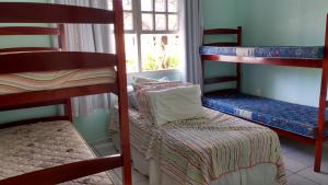 a room with two bunk beds and a chair at Casa do Gaspar in São Francisco do Sul