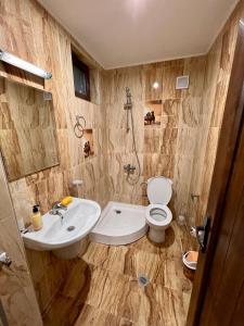 W łazience znajduje się umywalka, toaleta i prysznic. w obiekcie Къщи за гости Фантазия w mieście Dospat