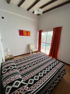 Un dormitorio con una cama con una manta estampada. en Raices Departamento 2, en San Rafael