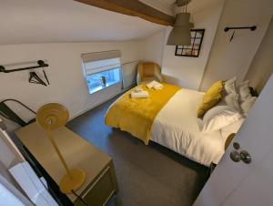 a bedroom with a bed and a table and a window at Rush Hill Cottage - with parking for 2 cars in Bath