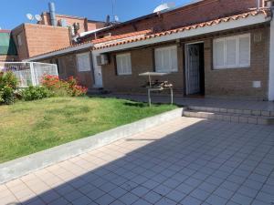 a brick house with a patio and a yard at Cabañas San Gabriel Carlos Paz in Villa Carlos Paz